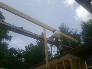 Carpenter setting a ridge beam over a new addition frame — Ice Dam Removal by Roofing Brothers in Genoa City