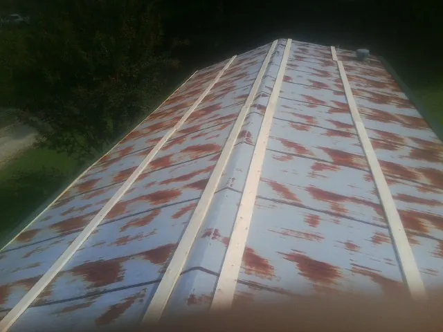 Rusted metal roof panels with new wood purlins before replacement — Storm Damage Roof Repair in Genoa City by Roofing Brothers