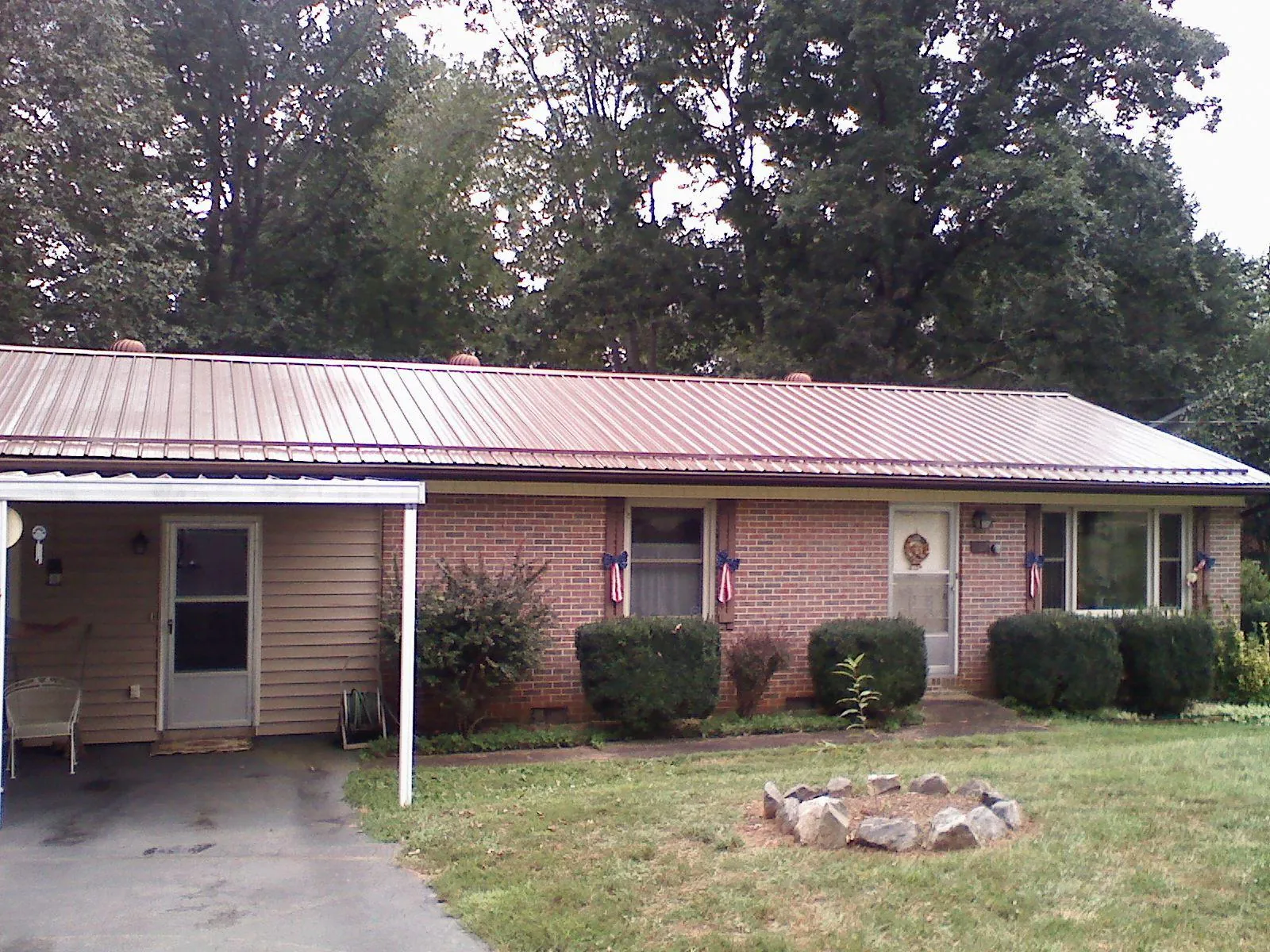 Bronze metal roof and carport on a brick ranch home — Roof Repair work by our crew in Genoa City