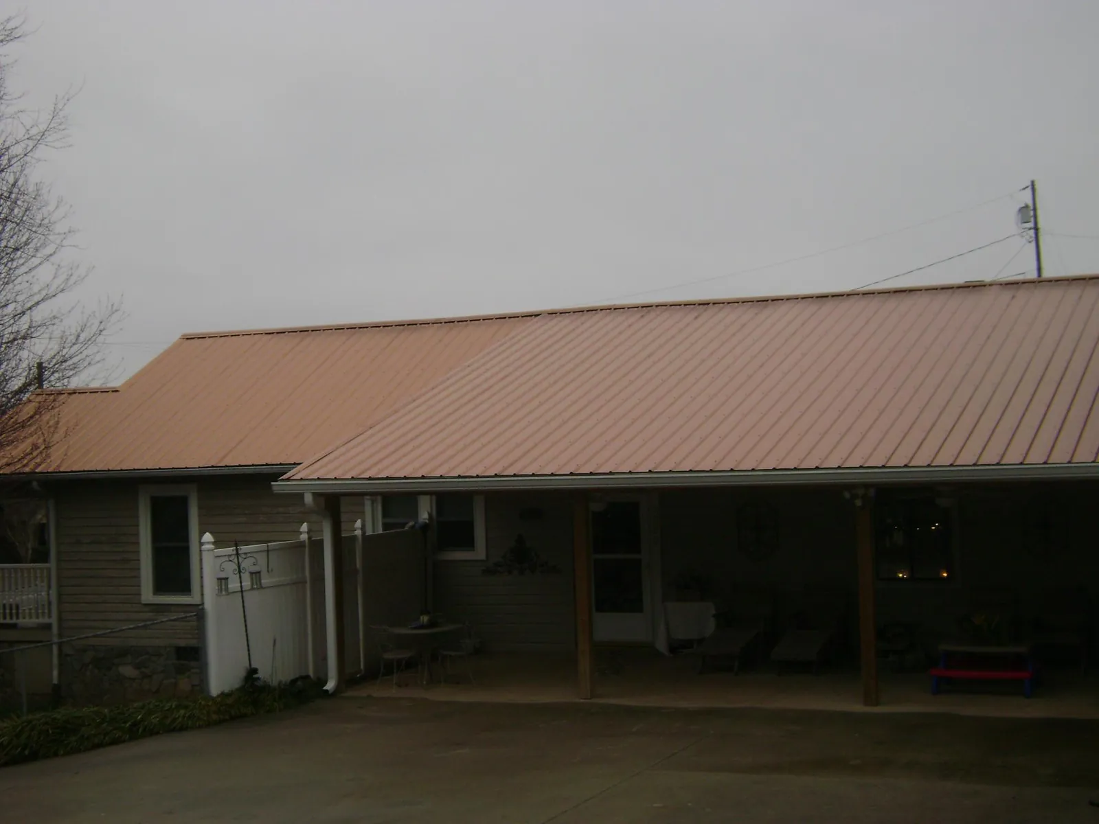 Copper toned metal roof over a wide covered patio in Genoa City